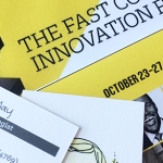 Emily May's business card on top of the Fast Company Innovation Festival brochure