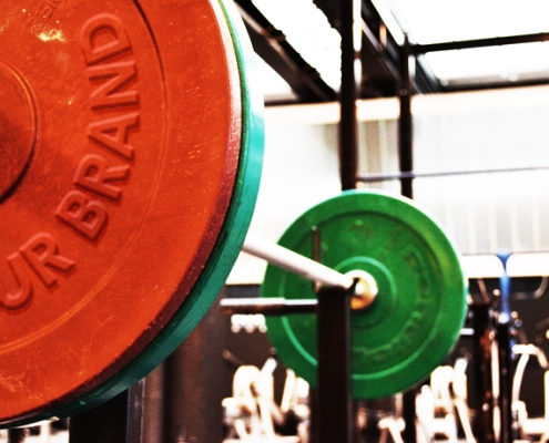 Stylized picture of a barbell with the "brand" on one of the plates