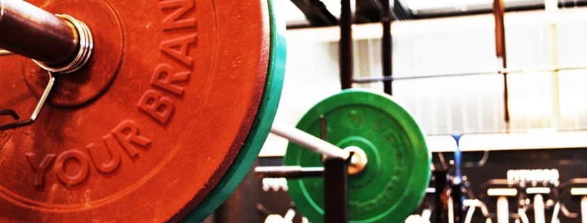 Stylized picture of a barbell with the "brand" on one of the plates