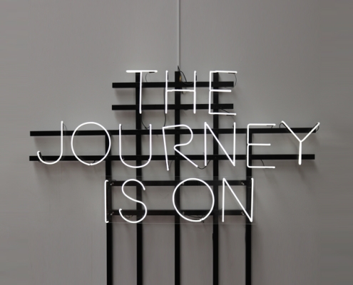 Light up sign reading, "The Journey Is On"