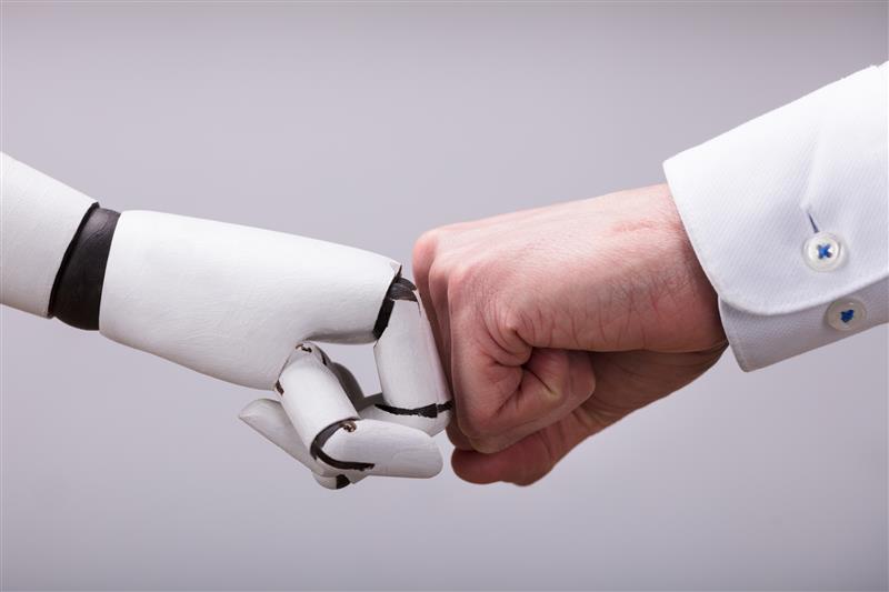 Robot hand fist bumping a human hand